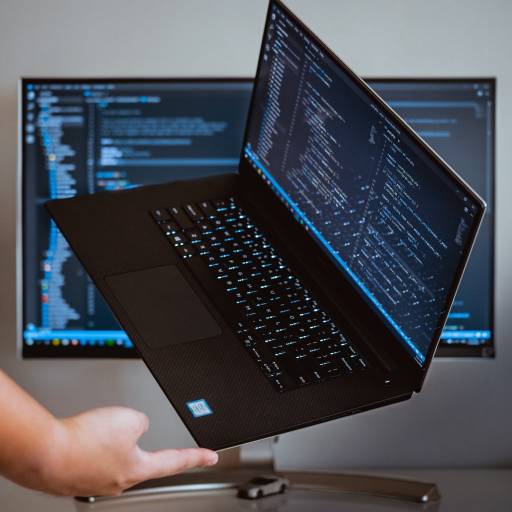 Laptop balanced on finger, with code on screen